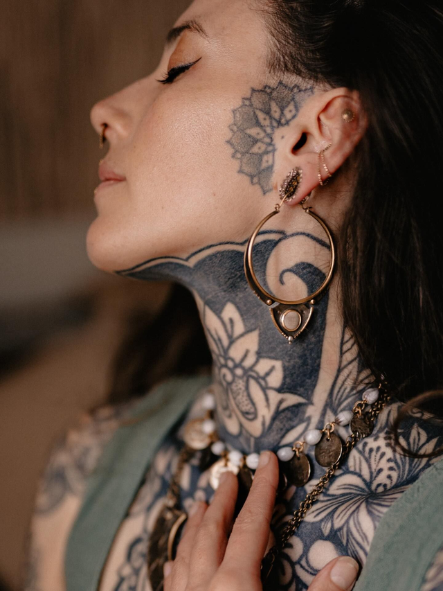 Boucles d'oreilles créoles, portées par un modèle. Créations artisanales en laiton, argent 925 et graine de canique.