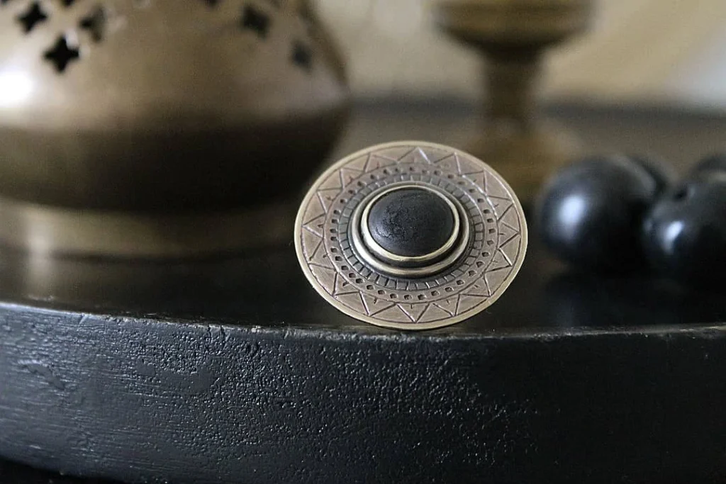 Bague La Magma en laiton gravé sertie d'ivoire végétal carbonisé, vue de face, posée sur ardoise - Seeds Créations artisanales
