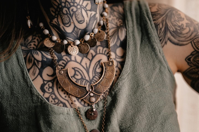 Gros plan du collier plastron "Le Gris Bleu" avec graine de canique grise et graines de larmes de Job sur laiton et argent vieillis. Seeds créations